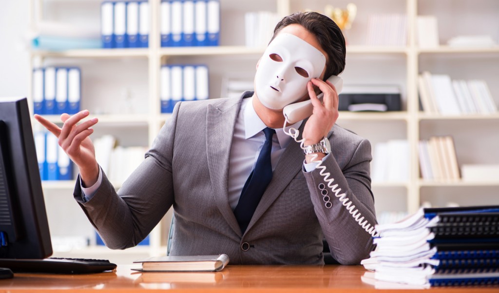 Businessman with mask in office hypocrisy concept