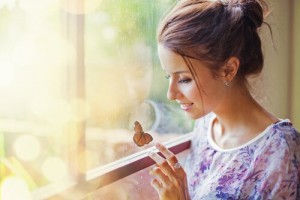 mujer-mirando-mariposa-ventana
