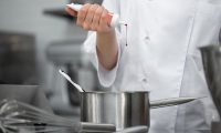 El chef pastelero añade colorante rojo al relleno del pastel. Por ejemplo.